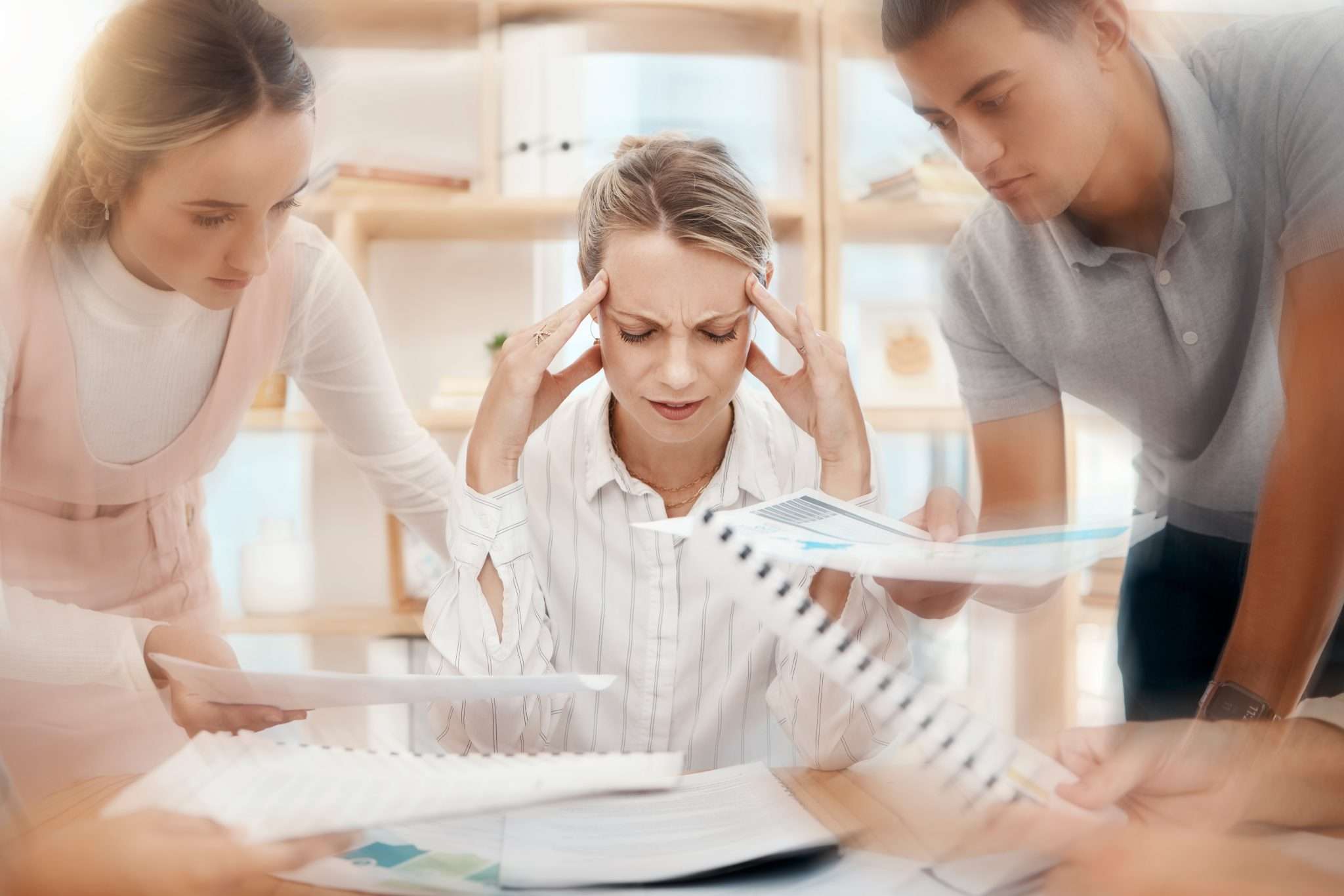 Manager stressé entouré de collègues au travail