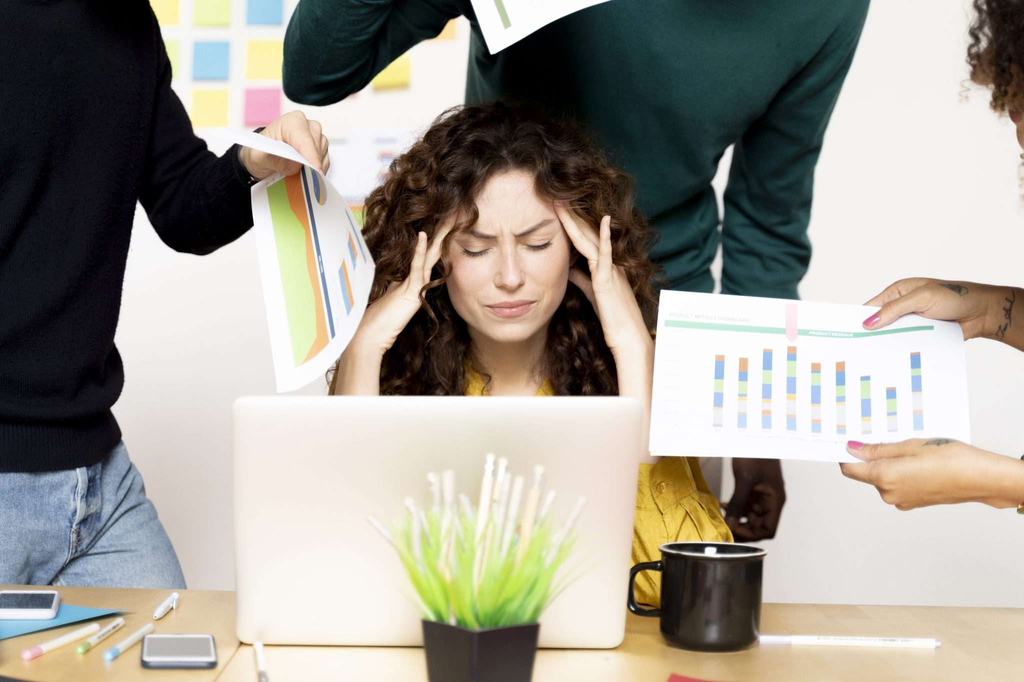 Femme stressée à son bureau entourée de dossiers
